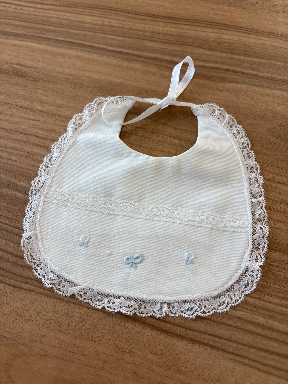 BAVETTA CON FIOCCHI CELESTE E RICAMI ARTIGIANBABY